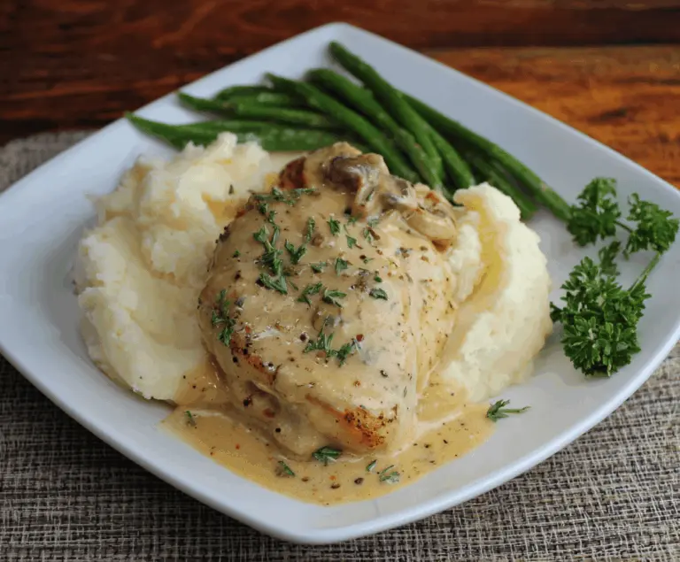 Delicious chicken topped with creamy Dijon sauce served with fluffy mashed potatoes on a plate.
