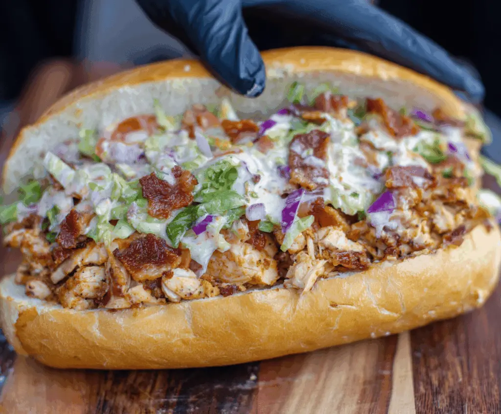 Delicious chopped chicken bacon ranch sandwich with crispy bacon, tender chicken, fresh lettuce, and creamy ranch sauce on toasted bread.