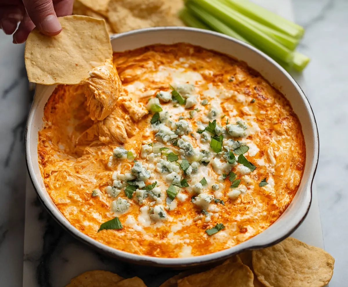 Creamy Spicy Buffalo Chicken Dip served in a bowl with celery sticks and tortilla chips for a tasty appetizer.