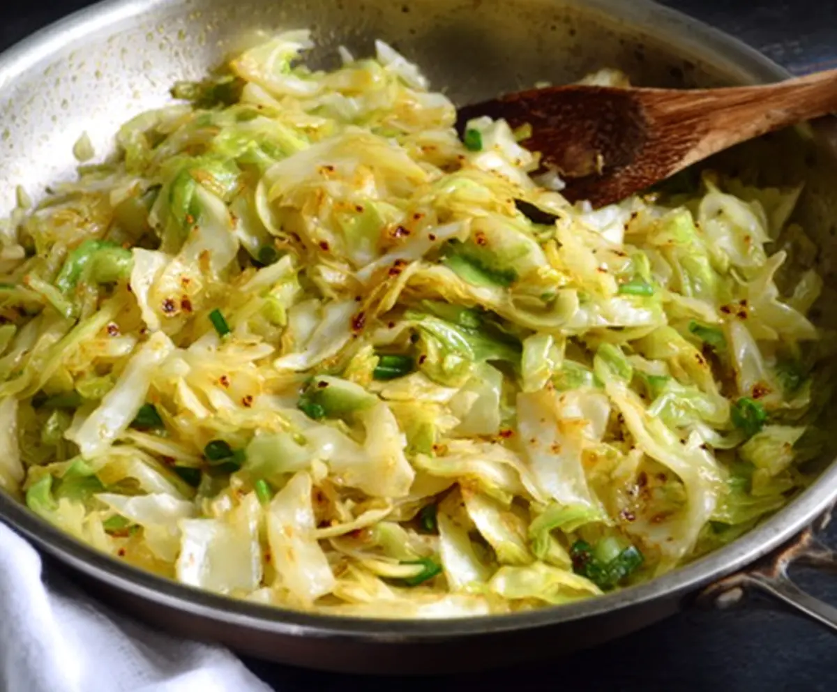 Delicious garlic butter sautéed cabbage served on a white plate with fresh herbs
