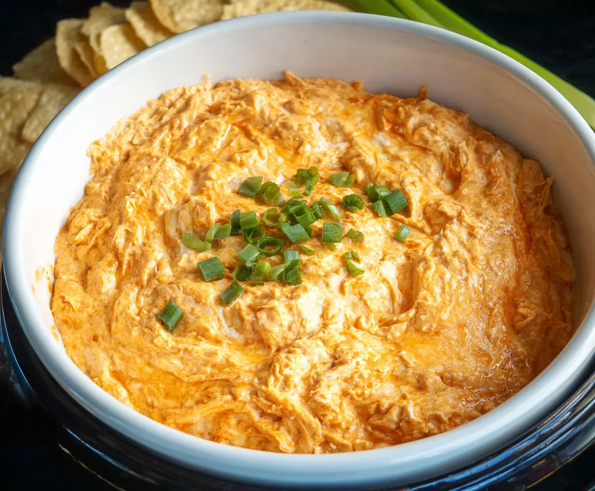 Delicious Crock Pot Buffalo Chicken Dip served with celery and tortilla chips for party snacking.