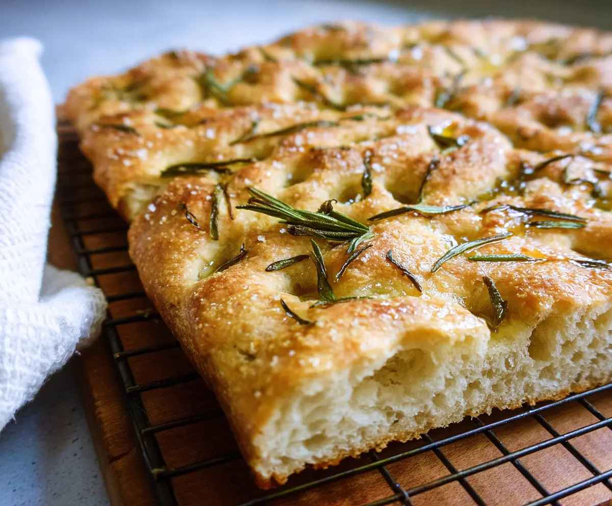Delicious sourdough discard focaccia topped with fresh rosemary and olive oil, golden and crispy crust.