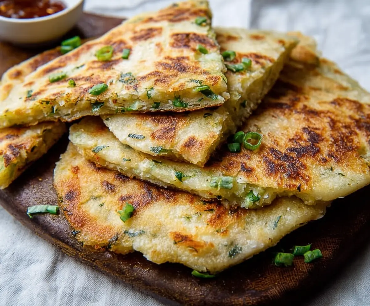 A plate of traditional Irish Potato Farls served with butter and herbs, showcasing their golden-brown crust and soft interior.
