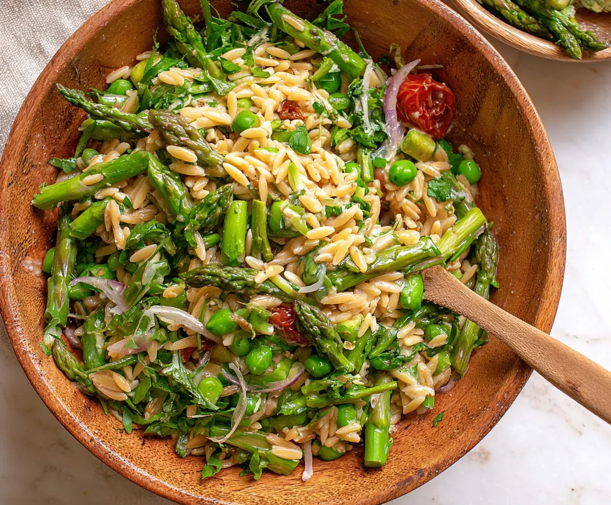 Fresh orzo salad with vibrant asparagus and colorful vegetables, perfect for a light meal.